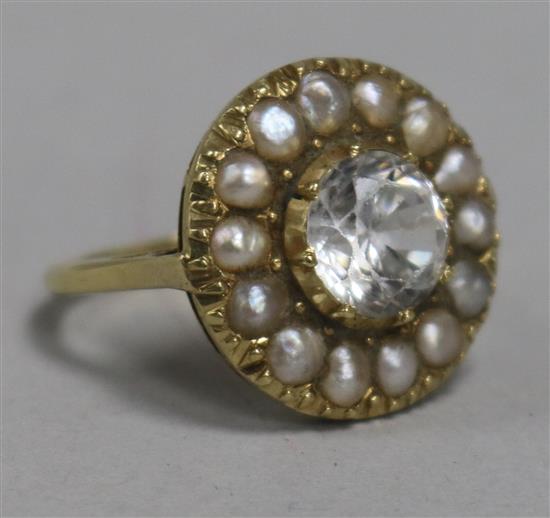 A white zircon and seed pearl cluster ring, claw-set in textured yellow metal setting